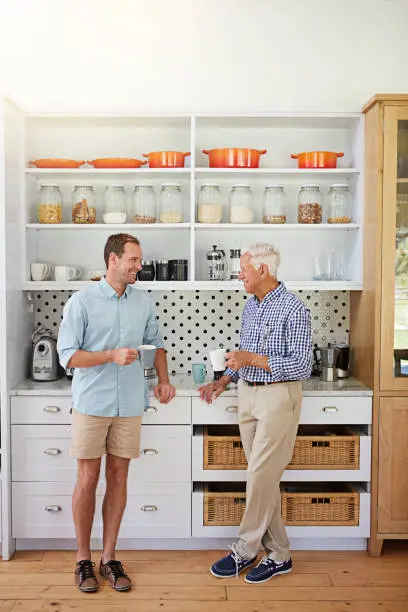 Shot of a man and his elderly father catching up over coffee in the kitchen