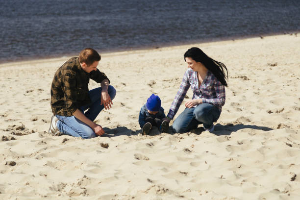 istock Happy young family having fun on beach at sunset 681767176