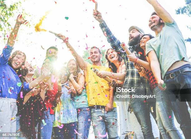 幸せな友人のパーティーを楽しんで紙吹雪を投げると煙爆弾色を使用して屋外のパーティーで - パーティーのストックフォトや画像を多数ご用意 - パーティー, 大学生, お祝い