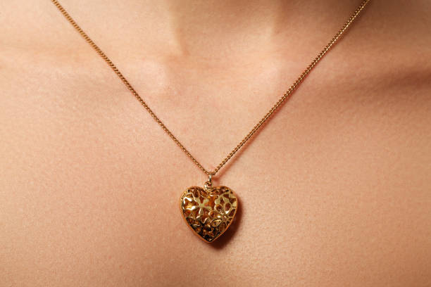 colgante de corazón dorado. concepto de belleza y joyería. mujer usando - heart pendant fotografías e imágenes de stock