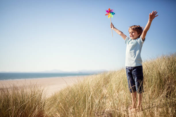 Child playing in sand dunes at the beach on summer vacation