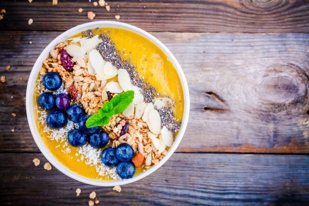 istock Yellow smoothies bowl with blueberries, granola, chia seeds and almonds 681792316