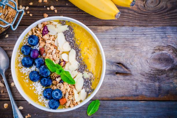 istock Yellow smoothies bowl with blueberries, granola, chia seeds and almonds 681792534