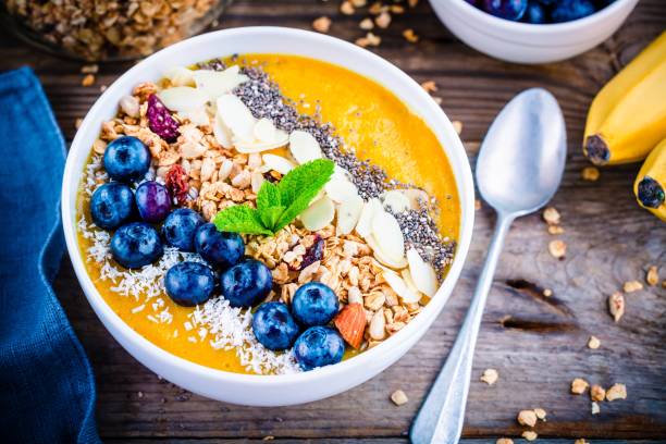 istock Yellow smoothies bowl with blueberries, granola, chia seeds and almonds 681792688