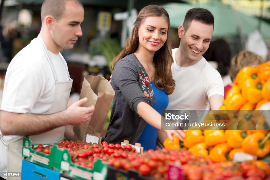 couple-choosing-pepper-from-salesman-at-