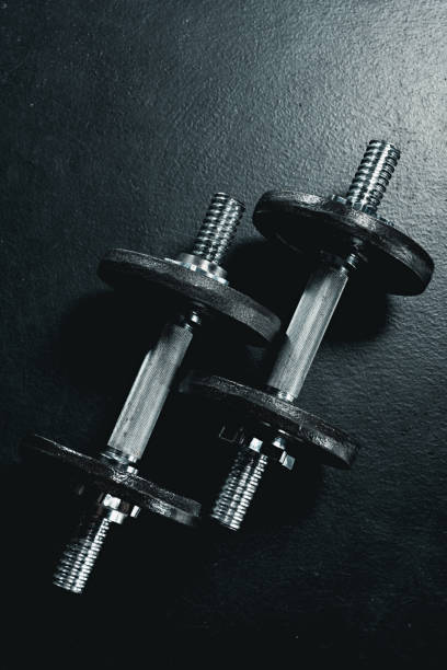 istock two metallic dumbbells lying on black floor in gym 681800330