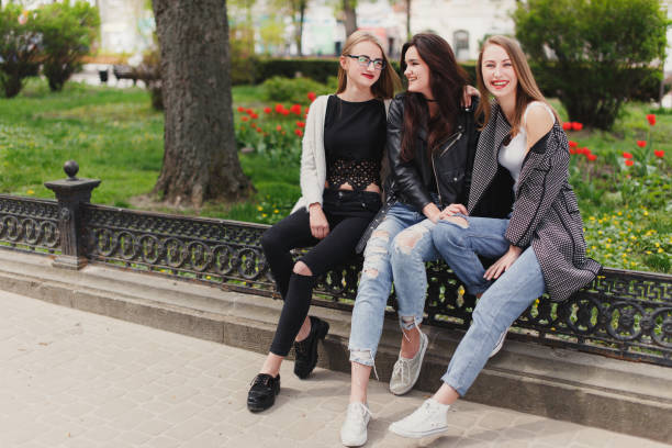 istock Three girls sit on the park background 681803334