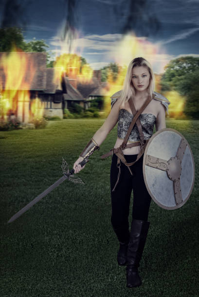 istock woman warrior walking away from burning village 681806948