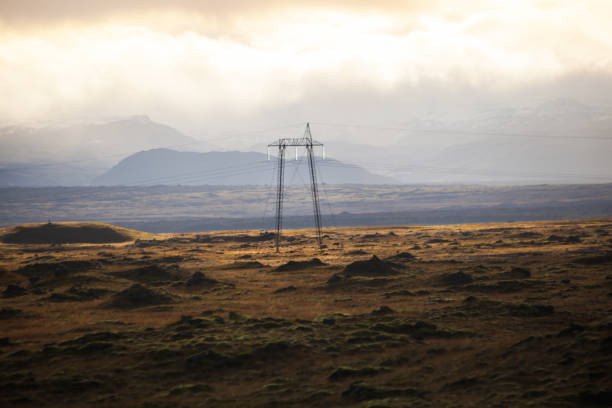 istock Power pole with sunset in Iceland. Light and shadow over the landscape. Beautiful mountain range in the backgrond. Tough nature. 681811512