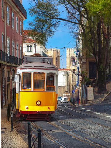 Famous vintage yellow 28 tram on street of Alfama, the oldest district of the Old Town, Lisbon, Portugal
