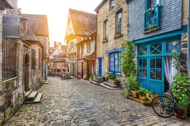 Panoramic view of a charming street scene in an old town in Europe in beautiful evening light at sunset with retro vintage Instagram style pastel toned filter and lens flare sunlight effect in summer