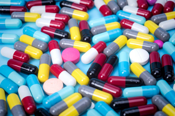 istock many scattered Colorful pills on blue background 681828288
