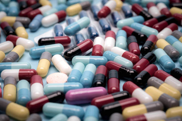 istock many scattered Colorful pills on blue background 681828326
