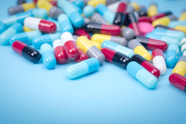 istock many scattered Colorful pills on blue background 681828354