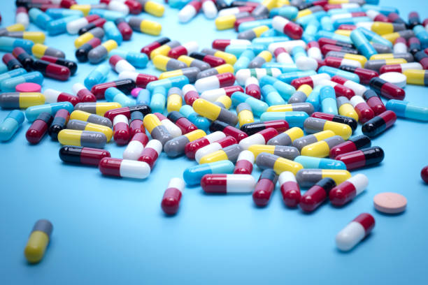istock many scattered Colorful pills on blue background 681828438
