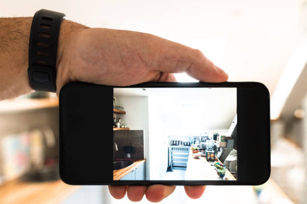 istock holding the smartphone and photographing the kitchen 681834646