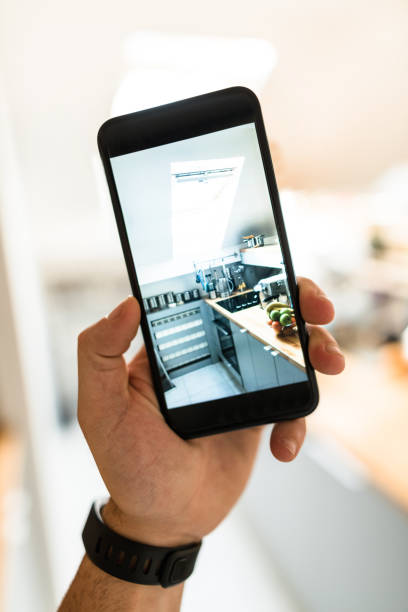 istock holding the smartphone and photographing the kitchen 681834690