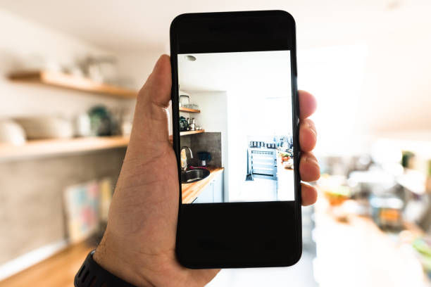 istock holding the smartphone and photographing the kitchen 681834802