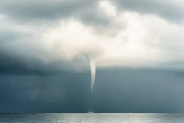 A tropical typhoon moves violently over the Andaman Sea, Krabi, Thailand.  This extreme weather event is rarely photographed due to the dangerous circumstances.  Typhoons, also known as tornado, cyclone or hurricane, are unfortunately becoming more common around the world, due to Global Warming and Climate Change.  These weather patterns are violent and dangerous, often claiming numerous lives in the areas which they occur.