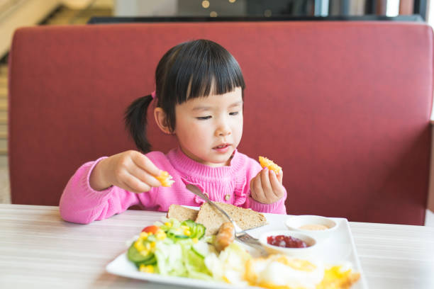 istock little girl eating breakfast 681838918