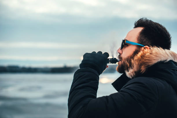 Man with beard smoke electronic cigarette stock photo
