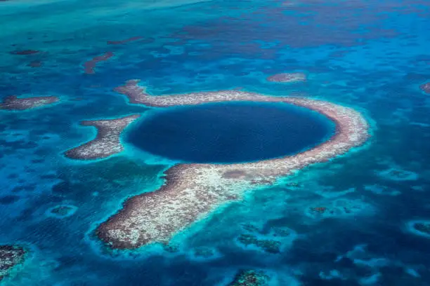 Aerial View to the famous diving site and natural phenomenon - the Blue Hole in the Lighthouse Reef, East of the Turneffe Atoll in Caribbean Sea, Belize, Central America.
