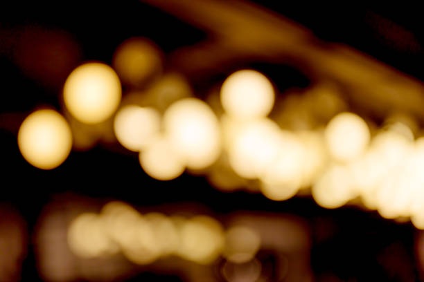 istock Abstract blurred bokeh of light bulbs decorated hanged from ceiling in department store. 681846290