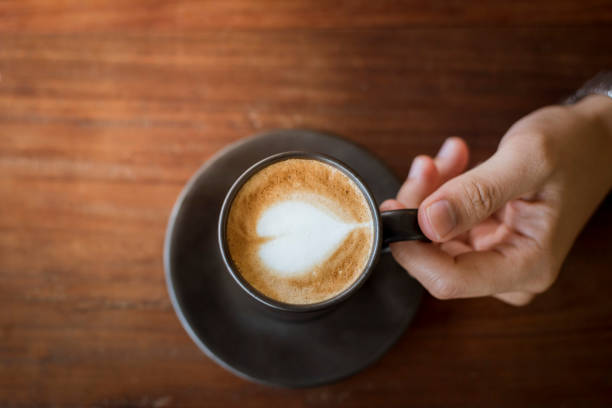 istock Hot latte art with  black glass on wooden table 681848390