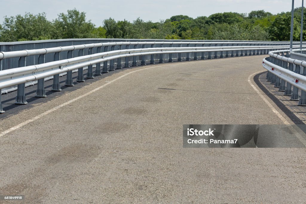 Modern asphalt road with metal fences and walkway closeup Modern asphalt road with metal guard rails and walkway for pedestrians, closeup Railing Stock Photo