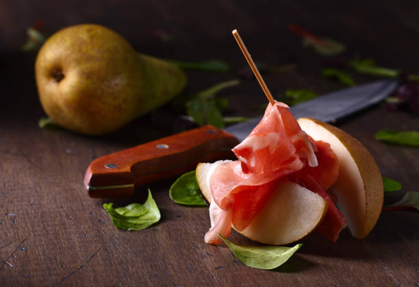 istock prosciutto with pear on a wooden table 681853454