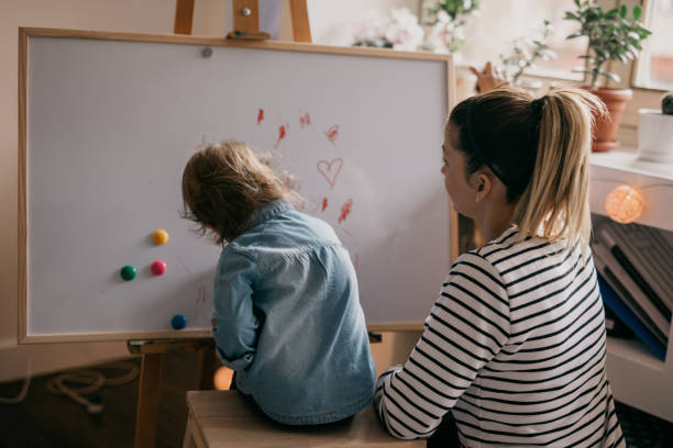 istock Mother and child drawing on the white board 681853604