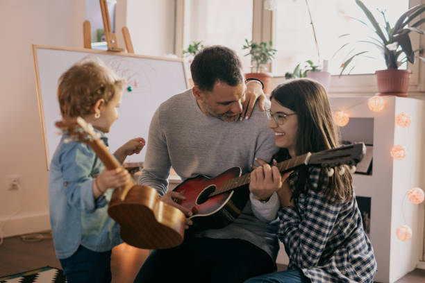 istock Single father playing a guitar to his daughters 681856296