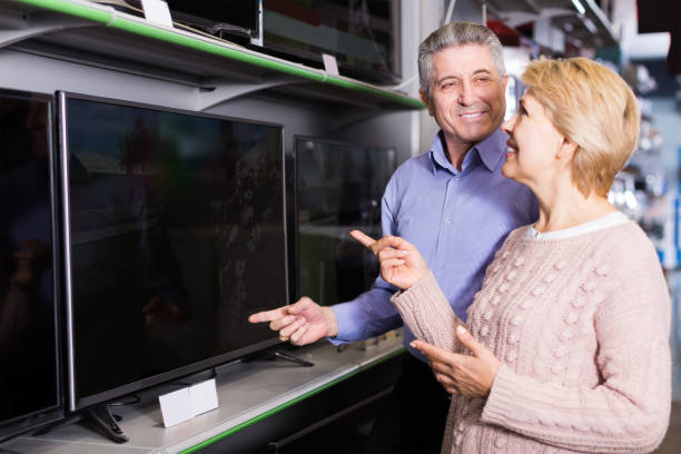 istock Nice mature married couple are choosing home modern TV 681882940