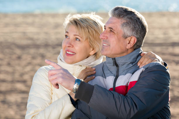 istock Mature couple walks outdoors and point by hand 681883224