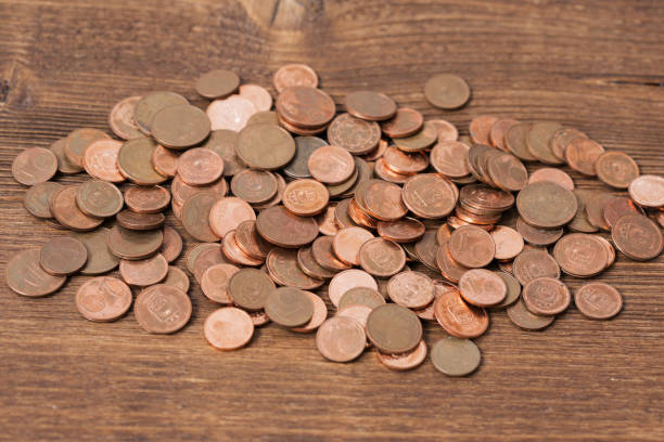 istock Many coins on wooden background 681886582