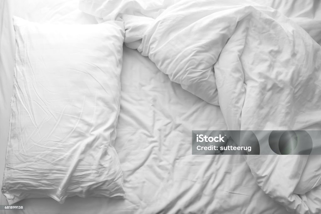 Messy bed. White pillow with blanket on bed unmade. Concept of relaxing after morning. Messy bed. White pillow with blanket on bed unmade. Concept of relaxing after morning. With lighting window. Black and white theme. Bed - Furniture Stock Photo