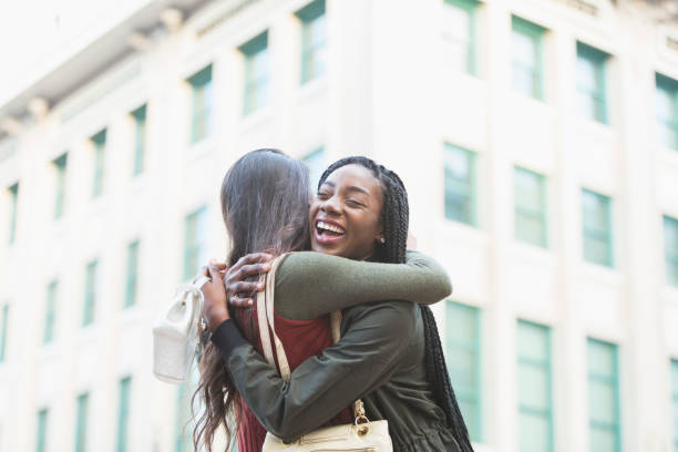 istock Two young women embracing on street corner 681899310