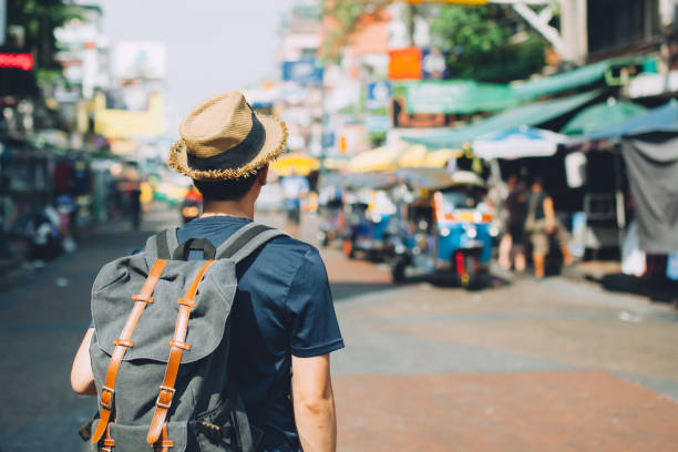 молодой азиатский путешествия пеший турист в khaosan road открытый рынок - walking tour стоковые фото и изображения