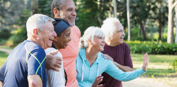 gruppo di cinque anziani multietnici in piedi nel parco - senior adult senior couple exercising african ethnicity foto e immagini stock