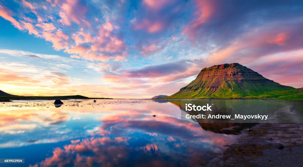 Colorful summer sunset with Kirkjufell Mountain in Grundarfjordur town Colorful summer sunset with Kirkjufell Mountain in Grundarfjordur town. Evening scene on the Snaefellsnes peninsula, Iceland, Europe. Artistic style post processed photo. Sunset Stock Photo