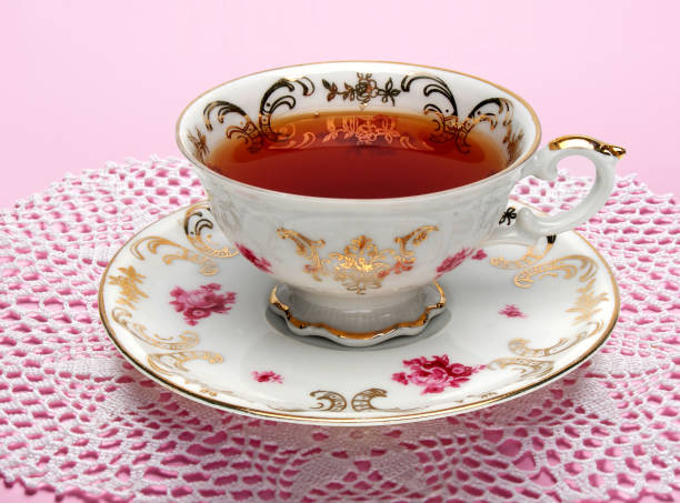 античная чашка чая, полная чая на столе - afternoon tea china antique cup стоковые фото и изображения