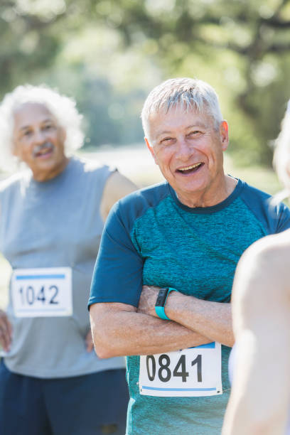 istock Senior man standing with other runners after race 681903238