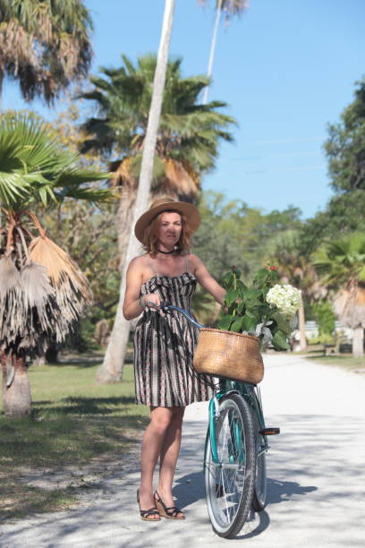 istock Woman riding bicycle in a tropical park. 681903606