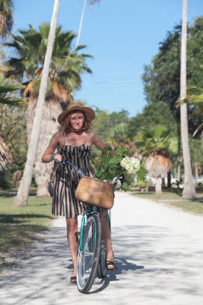 istock Woman riding bicycle in a tropical park. 681906720