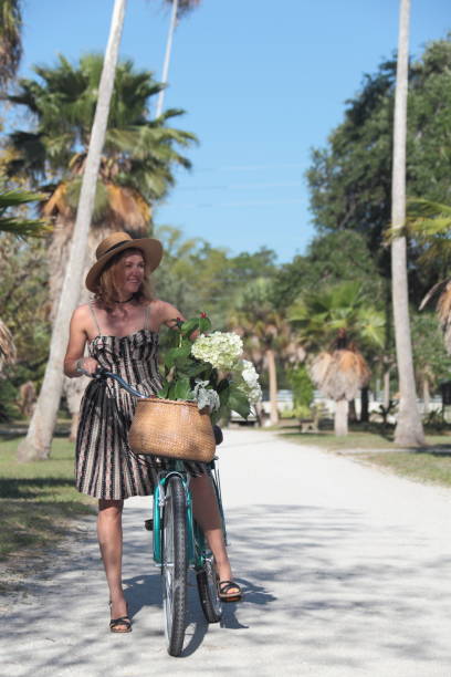 istock Woman riding bicycle in a tropical park. 681906724
