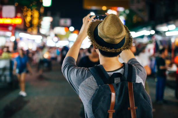 joven viajero asiático tomar foto con el teléfono en la noche calle - khao san road fotografías e imágenes de stock