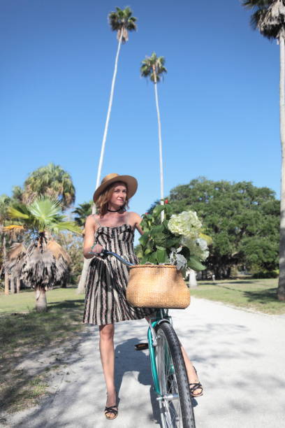 istock Woman riding bicycle in a tropical park. 681910434