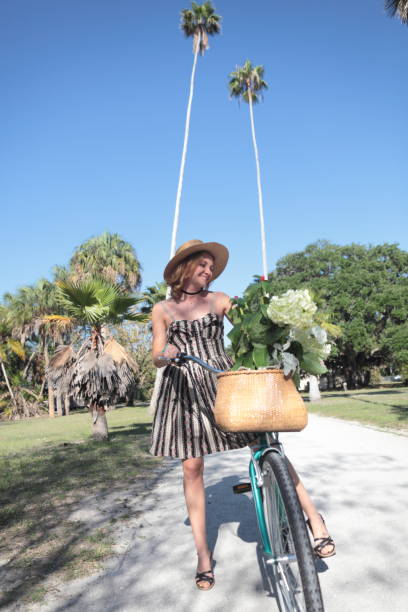 istock Woman riding bicycle in a tropical park. 681910728
