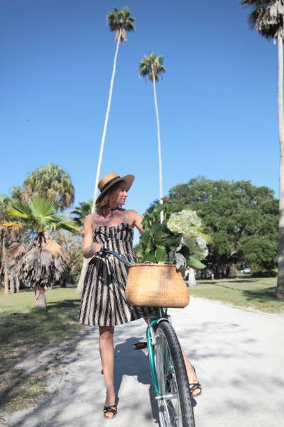 Woman riding bicycle in a tropical park.
