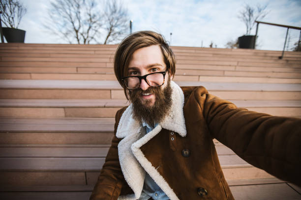 good looking bearded guy taking photo of himself with his smartphone. - stubble men tattoo sensuality imagens e fotografias de stock